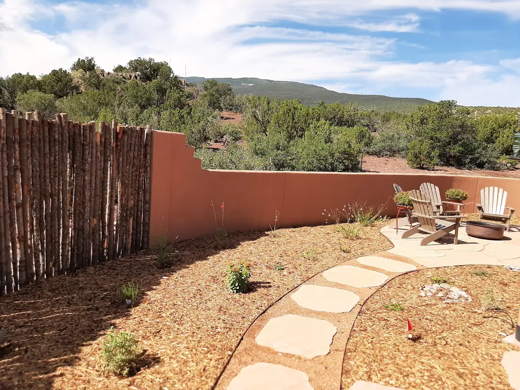 Rustic log picket fence against a stucco wall on an Albuquerque property